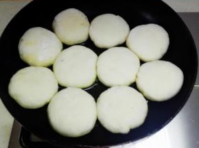 将压扁的香菇酱饼放入油锅，中火开始煎