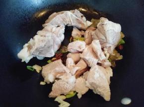 炒出香味后将焯水的蹄髈煸炒。