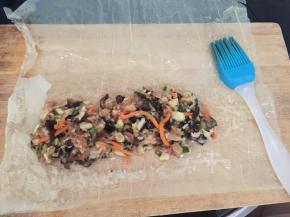 将腐皮平铺在案板上，放入适量馅料，用水淀粉刷四周