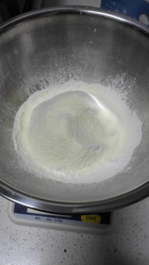 准备材料
先将黄油取出切块软化
粉类（曲奇粉，奶粉，泡打粉）混合过筛备用；
柠檬洗净，刨皮，切碎备用