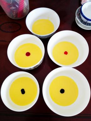 其中四份蛋黄糊内，每份挤入不同颜色的色素一滴