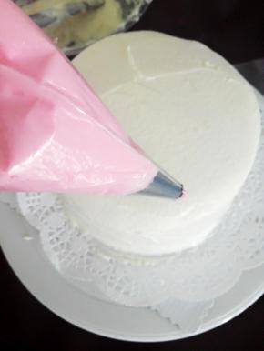 小的八齿裱花嘴放入裱花袋，放入红色奶油霜，裱花袋剪一个小嘴