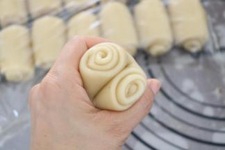 将卷好的成品，用拇指在中间压一下，用虎口位置把卷对夹起来