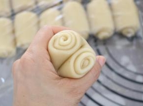 将卷好的成品，用拇指在中间压一下，用虎口位置把卷对夹起来