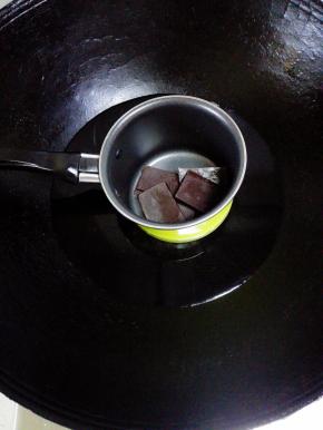 巧克力掰碎放入奶锅中，小火隔水融化后冷却备用