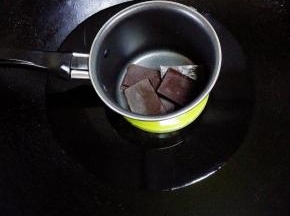 巧克力掰碎放入奶锅中，小火隔水融化后冷却备用