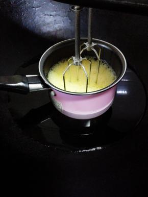 鸡蛋和细砂糖放入奶锅中，隔水一边小火加热一边用电动打蛋器搅打，搅打至蛋液达到体温，关火，取出奶锅。