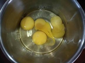 拿一个盘，在里面打4个鸡蛋，用手动打蛋器打散。