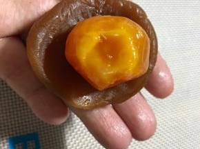 蛋黄凉透后再包，我的蛋黄是中号的，用的50克月饼模具，50克模具应该用小号蛋黄更合适，或者中号蛋黄，用75克的模具也可以。用掌心压扁馅球，放入蛋黄
