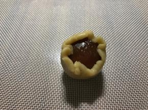 再把面皮稍微压扁，放入馅球，虎口慢慢收口包好。