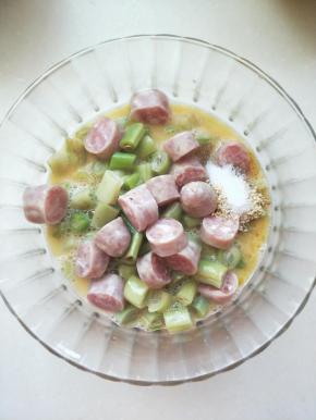 将切好的香肠和豆角放入鸡蛋液碗中，加入盐，鸡精调味，这个用量要根据自家的口感调解。