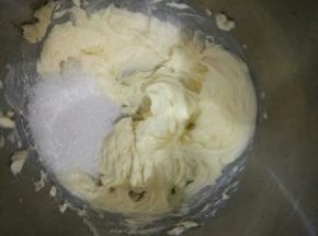 将打顺滑的黄油里加入一半的白砂糖，继续用电动打蛋器打直白糖基本溶解。