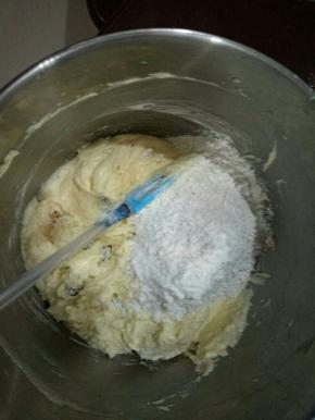 加完葡萄干再加入过筛好的低粉。先加入1/3，拌匀。一定要翻拌。