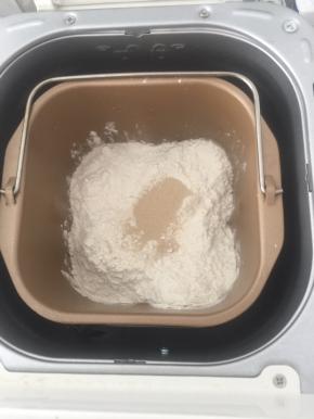 除黄油外的其他材料按牛奶，糖，盐，中筋粉，全麦粉，干酵母的顺序称入面包机桶