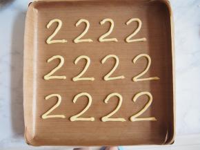 将面糊装入裱花袋，剪开小口，在烤盘上画出2的形状，放入220度烤箱中烤2分钟膨胀上色。