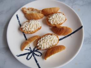 将泡芙底部隔开，上半部分再剪成两半，填上淡奶油，摆好天鹅头和翅膀。