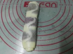取出松弛好的面团，收口朝上压扁，再次擀长，注意宽度厚薄要尽量均匀，这样酥的层次才好看；然后也是自上而下卷起；这样可以看出层次是均匀的；其余颜色一样擀长卷起，也是盖上保鲜膜松弛十分钟
