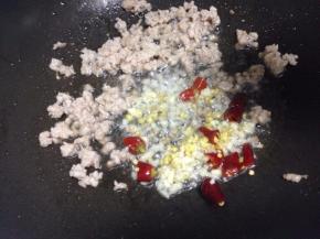 然后把肉末铲到边，放入姜蒜末辣椒爆香