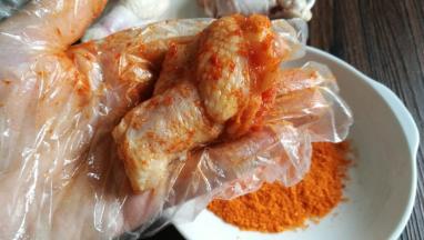 用手把烤肉料给翅根抹匀，适当按摩下。