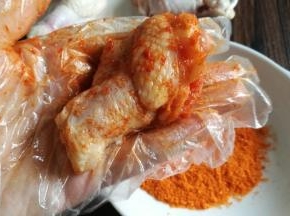 用手把烤肉料给翅根抹匀，适当按摩下。