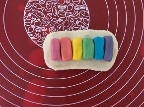 取一个油皮，擀成椭圆形，油酥一个个摆成一排