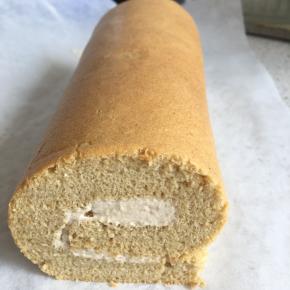 用油纸裹着蛋糕慢慢卷起，一边卷起，一边拉出卷进去的油纸