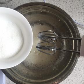 用电动打蛋器低速打发至蛋清呈粗泡，加入1/3的细砂糖，继续中速打发