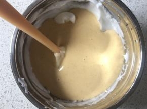 最后把翻拌均匀的蛋糕糊全部倒入剩下的蛋白霜中，翻拌均匀