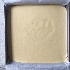 方盘垫上油纸，倒入蛋糕糊，在桌上轻磕几下震出大气泡