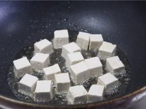 平底锅倒入少许的油，油温烧至7成热，放入豆腐小火煎至四面金黄