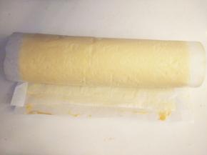 将蛋糕体从有黄桃块的一端卷到另一边，接口朝下，入冰箱冷藏片刻