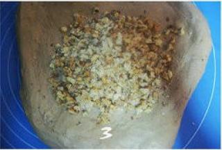 把面团压扁，倒入核桃碎；