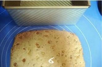 发酵好的面团排气，压扁，擀成与模具等宽的长方形面片；