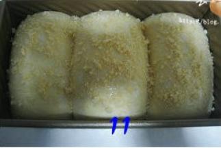 面团发酵至九分满，表面刷蛋液，撒上酥松粒；