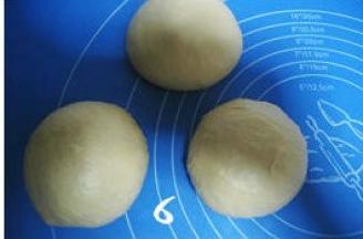 将发酵好的面团排气，分割三等份，分别滚圆，盖上保鲜膜松驰15分钟；