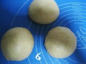 将发酵好的面团排气，分割三等份，分别滚圆，盖上保鲜膜松驰15分钟；