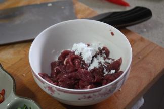 将牛肉加入1小汤匙泡打粉，蛋清和水一起搅拌均匀