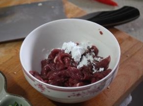 将牛肉加入1小汤匙泡打粉，蛋清和水一起搅拌均匀