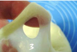 取出冷藏的面团，揉至扩展阶段后加入软化的黄油，继续揉摔至完全阶段；