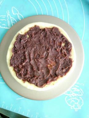 在擀好的面皮上面涂上一层豆沙馅，记住周围要留出来大概0.5-1厘米左右的空间不要涂抹，这样可以更好的收口。