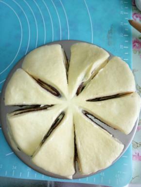 这样反复几次操作，把所有的面团都擀完并涂好豆沙馅。然后再用剪刀或者刀把面片分成4等份，然后再切成八等份，直至分成16等份为止，注意中间要留一些不要全部切开。