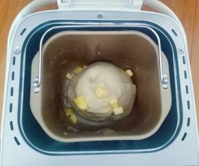 设置面包机和面程序20分钟，结束后加入软化的黄油继续和面20分钟