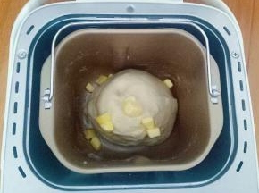 设置面包机和面程序20分钟，结束后加入软化的黄油继续和面20分钟