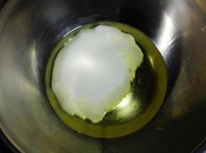 蛋黄和蛋清分离在两个无水无油的盆中，蛋白盆放入冰箱冷藏备用（也可不放）.
空盆内放入玉米油和酸奶，用手动打蛋器搅拌均匀