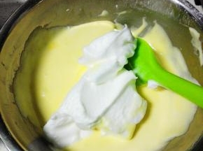 再取三分之一蛋白霜入蛋黄糊盆中，翻拌均匀,拌好的蛋黄糊全部倒入蛋白盆中，翻拌均匀