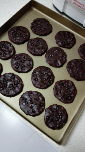 此时烤箱180度预热
用手将圆球按扁，放入烤盘中