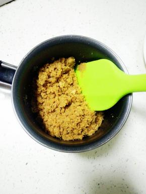 饼干屑倒入融化好的黄油中，拌匀