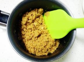 饼干屑倒入融化好的黄油中，拌匀