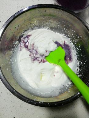 将蓝莓果酱液分三次倒入淡奶油盆中拌匀