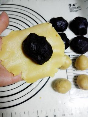 取一个面团，在手心压扁，放一颗玫瑰花酱馅